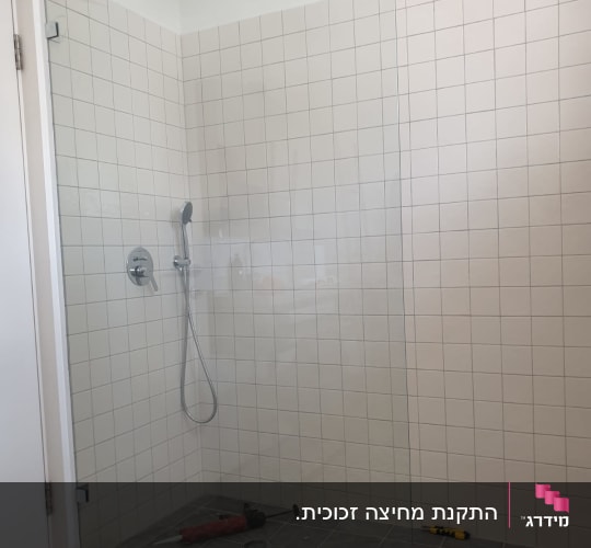 מחיצת זכוכית במקלחת עם ראש מקלחת